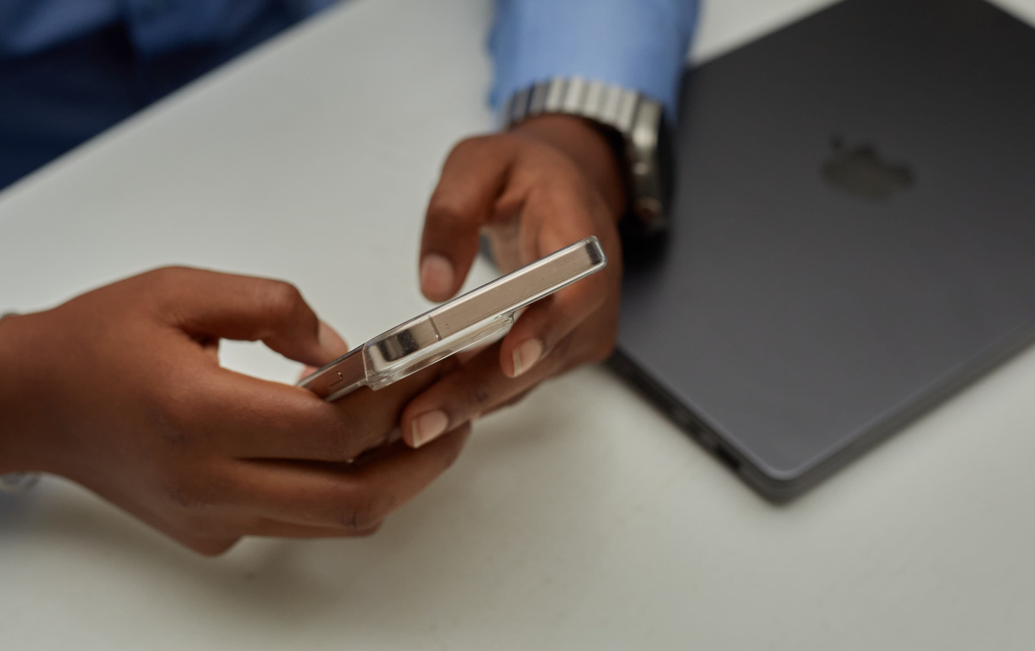 Person using a smartphone at a desk, representing ways to reach the Chiggy Foundation for Opportunity